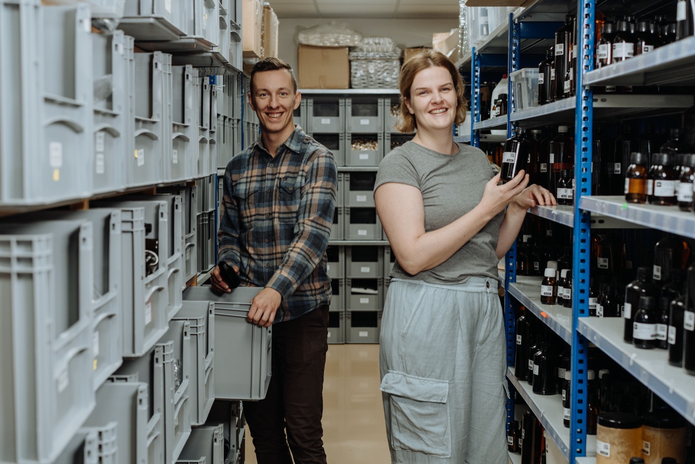 Almacén de Handymade — estanterías con materias primas en frascos y cajas de transporte