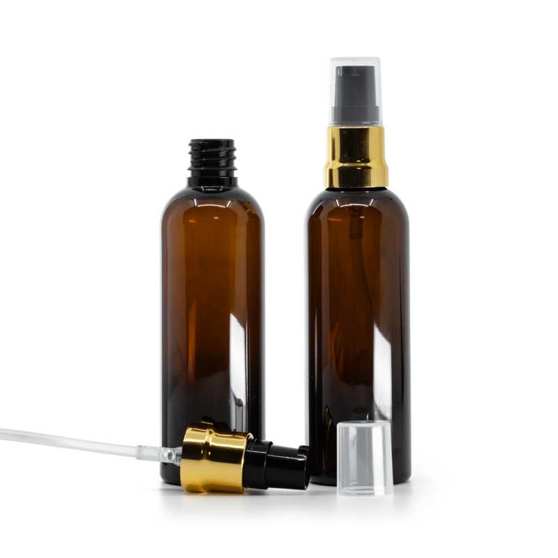 Botella de plástico, ámbar, dosificador negro y dorado brillante, tapón transparente, 100 ml